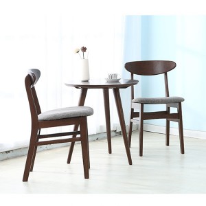 A dió színű kis kerek asztal és a tömörfa székek egyszerűek és elegánsak.